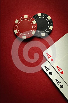 Four aces and chips on a red table in a poker club. Winning concept with four of a kind or quads combination. Space for photo