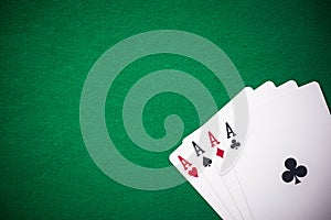 Four aces folded on green casino table, copy space