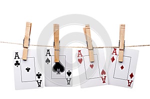 Four aces hanging from clothes pegs on a clothes l