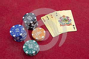 Four aces near stacks of chips on a red felt table