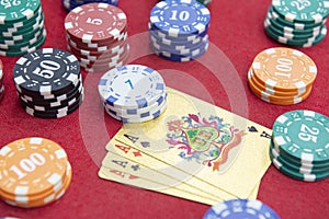 Four of aces near stacks of chips on a red felt table