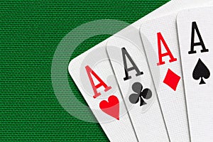 Four aces over green textile background