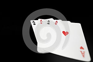 Four aces playing cards on black background