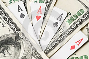 Four aces poker playing cards among U.S. dollars