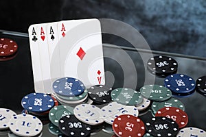 Four aces and poker playing chips on a mirror . Online gambling.