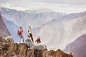 Four active friends on cliff mountain top