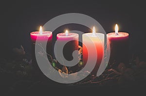 Four  advent candles burning on black background