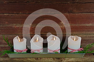 Four advent candles at an old weathered red wall