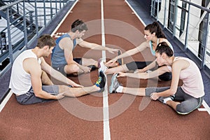 Four athletic women and men stretching