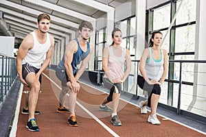 Four athletic women and men stretching