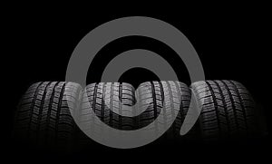 Four automobile rubber tires isolated on black