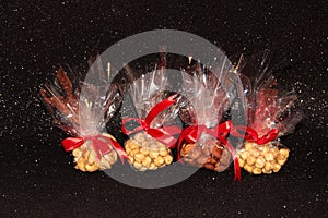 Four bags of nuts on a black background. Cashews, almonds, and hazelnuts in a package
