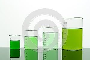 Four beakers with green liquid