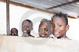 Four Beautiful African Black Children Smiling Cheerfully at Camera photo