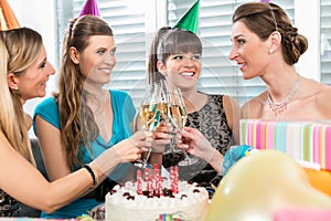 Four beautiful and cheerful women toasting with champagne