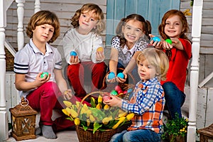 Four beautiful children, two boys and two girls stand on a wooden threshold and laugh