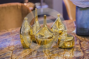 Four beautiful glossy golden vases. Gold fashionable glass vases on a marble table. Stylish luxirious interior element photo