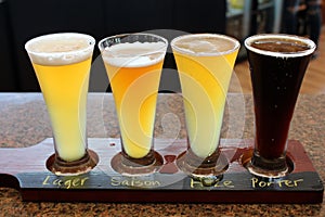 Four beer samplers set in wooden tray for craft beer lovers to try out and vote on