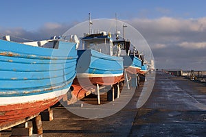 Four Blue fishing boats in dry dock waiting repair