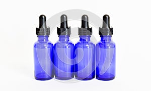 Four blue glass eyedropper bottles