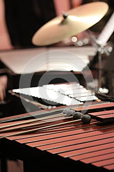 Four blue yarn mallets laying in row on brown wood marimba keys