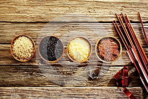 Four bowls of different rice with chopsticks