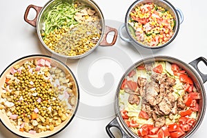 Four bowls with fresh vegetable salads and food