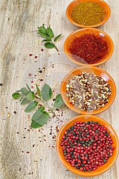 Four bowls with saffron, pepper, ras en hanout, fresh mint