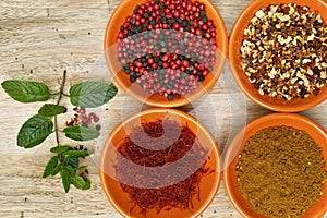 Four bowls with saffron, pepper, ras en hanout, fresh mint