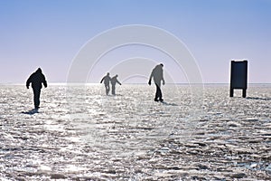 Four boys making a careful walk on a frozen lake