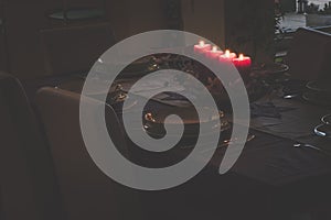 Four burning advent candles on the table prepared for christmas night