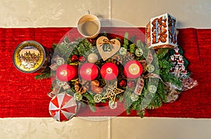 Four burning candles on a nice decorated advents wreath from a top-down view.