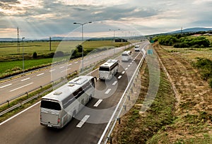 Four buses in line traveling on a highway