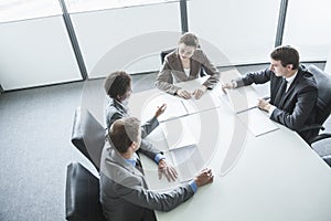 Four business people sitting around a table and having a business meeting, high angle view