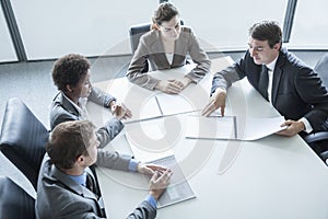 Four business people sitting around a table and having a business meeting, high angle view photo