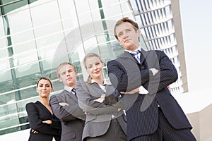 Four business people standing outdoors smiling