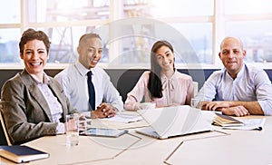 Four business professionals looking at the camera during a meeting