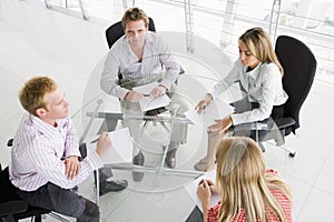 Four businesspeople in boardroom with paperwork