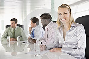 Four businesspeople in a boardroom smiling