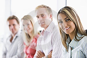 Four businesspeople sitting indoors smiling