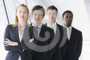 Four businesspeople standing in corridor