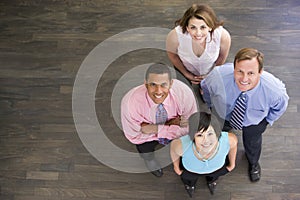 Four businesspeople standing indoors smiling