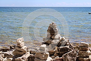 Four cairns at the water`s edge on a rocky shoreline of Lake Michigan in Cave Point County Park, Sturgeon Bay, Wisconsin