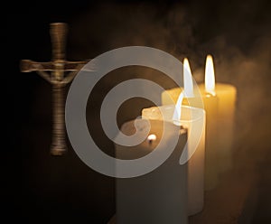 Four candles and a cross in the background.