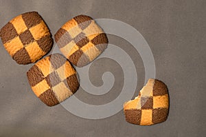 Four checker board cookies in plain black background