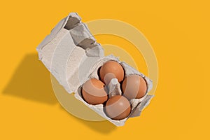 Four chicken eggs in cardboard egg