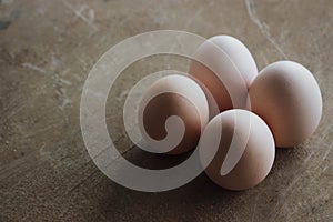 Four chicken organic eggs on wooden background. Spring raw fresh style