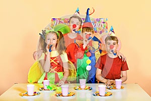 Four children blow to the tune for the birthday of their clown