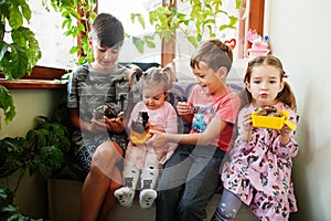 Four children holding their favorite pets on hands. Kids playing with hamster,turtle at home