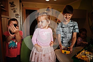 Four children holding their favorite pets on hands. Kids playing with hamster,turtle and parrots at home